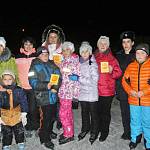Посетители ледового катка на курорте Приэльбрусье изучают действие световозвращателей